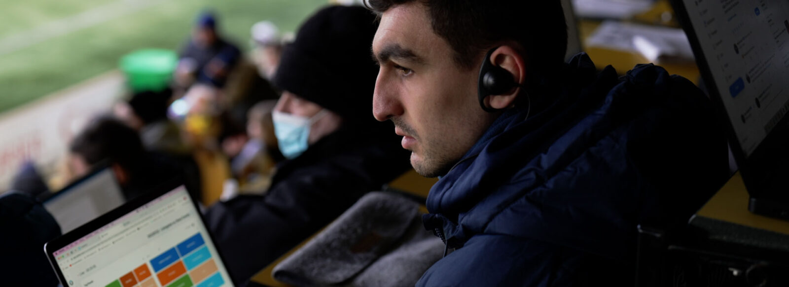Person in stands on arena analyzing a game.